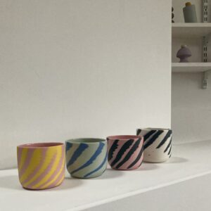 four colored porcelain cups thrown on the wheel using a marbling technique to leave a fun and funky design