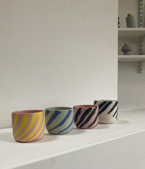 four colored porcelain cups thrown on the wheel using a marbling technique to leave a fun and funky design