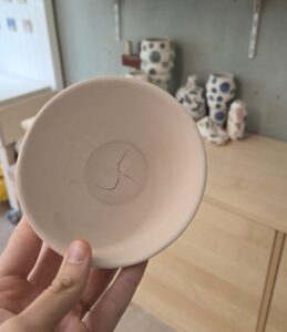 Keramikschale, die biskuitgebrannt wurde und einen S-förmigen Riss am Boden aufweist.