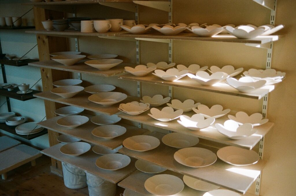 Idakumori ceramic studio shelves, full of handmade porcelain plates and bowls by Lilly Haas