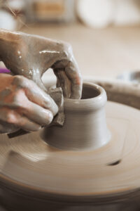 Hands during pottery work on the potter's wheel during an intensive pottery wheel course in Zurich at db pottery