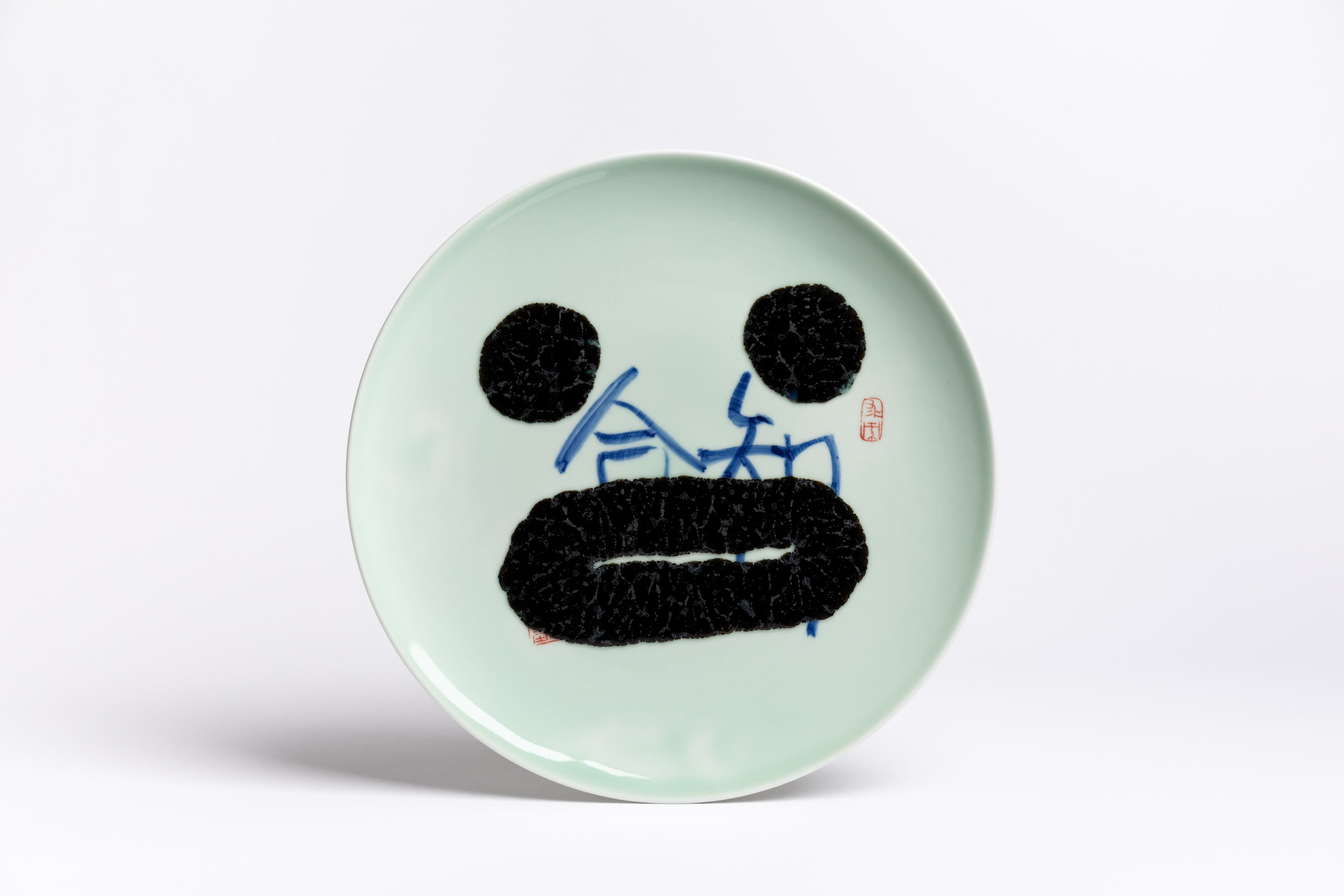 Mint green porcelain plate with heart-eyed smiley made of molten glass by Attua Aparicio — Glass on Ceramics Ceramic Workshop at Zurich Design Weeks