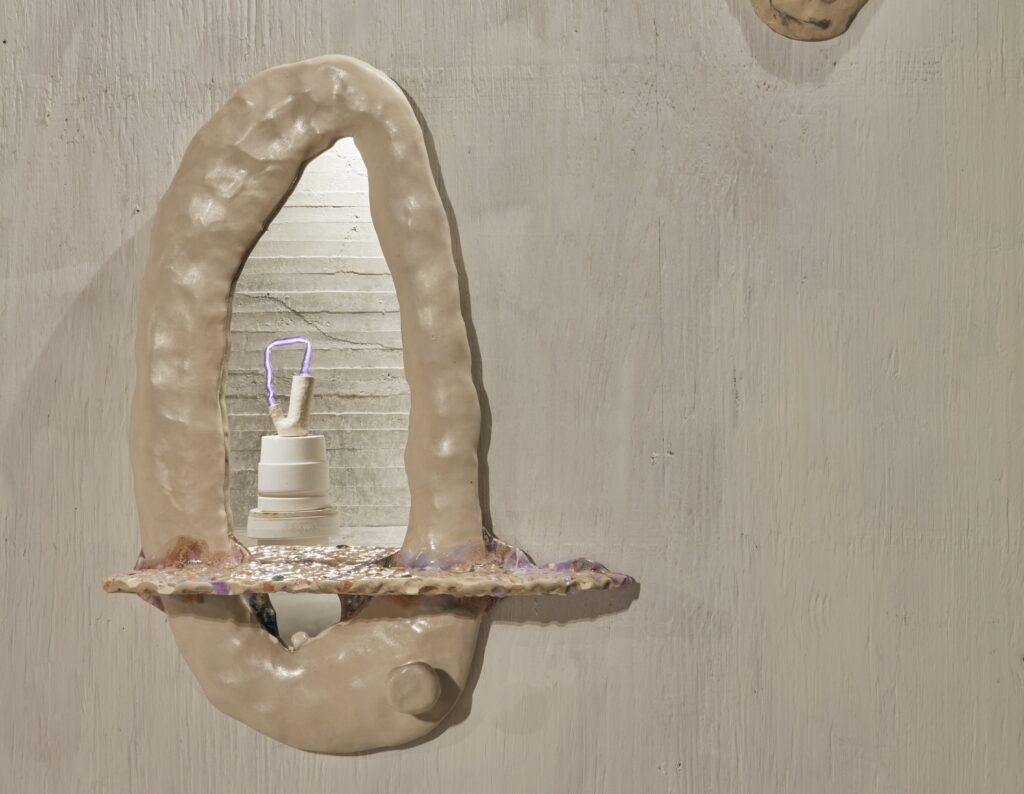 Handmade ceramic wall mirror with an organically shaped, cream-colored frame and a glossy speckled shelf, decorated with a small ceramic object — Mirror, Mirror Ceramic Workshop at Zurich Design Weeks at db pottery