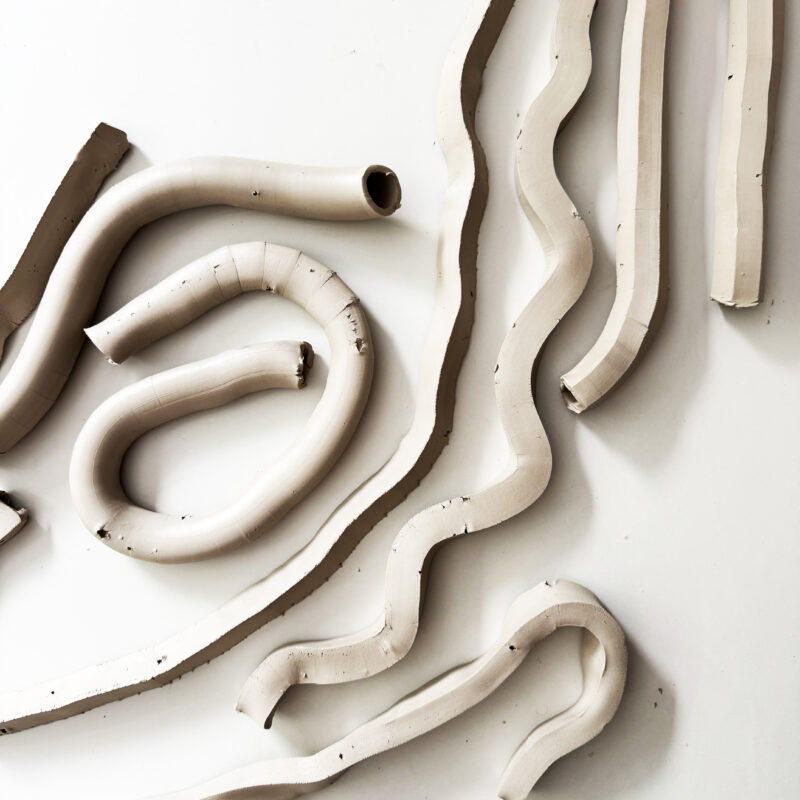 clay extrusion pieces freshly extruded and layed out on a table.