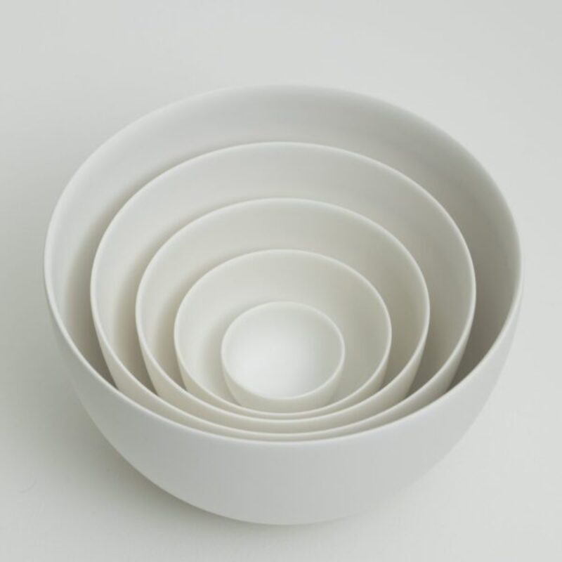 four white porcelain nesting bowls stacked together by Jaejun Lee for a porcelain workshop